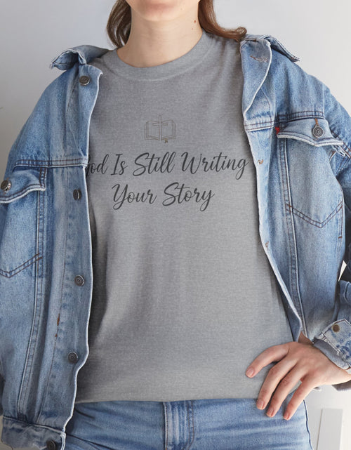 Load image into Gallery viewer, God Is Still Writing Your Story Tee — Inspirational Christian Faith Men's &amp; Women's T-Shirt
